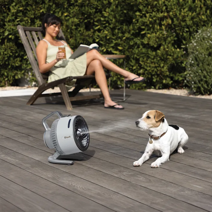 Mujer y perro en una terraza refrescándose con el Shark HydroGo en color gris
